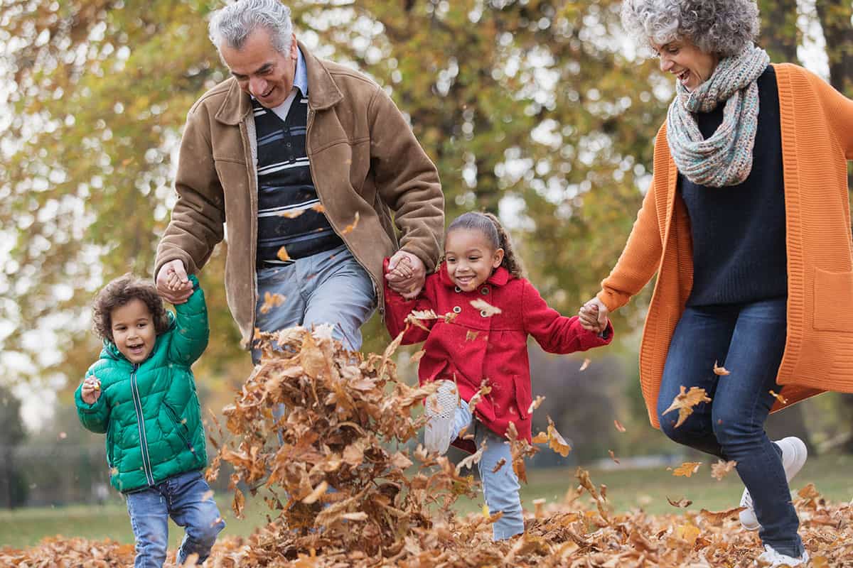 family playing with fall leaves in Portland, Oregon